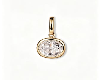 Può includere: Un ciondolo in oro con una pietra preziosa trasparente di forma ovale incastonata in una lunetta in oro lucido. Il ciondolo include una piccola contromaglia in oro liscio sulla parte superiore per l'aggancio a una catenina.