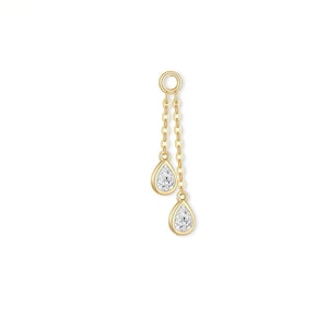 May include: A gold-colored earring with two teardrop-shaped, clear gemstones. The gemstones are suspended from a chain and connected to a small circular loop at the top.