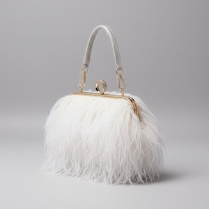 Op de afbeelding: Een witte, donzige clutch met een goudkleurige sluiting en een zilveren handvat. De tas heeft een ringvormige versiering op de sluiting. De tas is ontworpen voor formele gelegenheden.