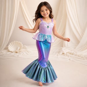 Pode incluir: Um vestido de fantasia com tema de sereia, apresentando um corpete lavanda com copas em forma de concha, uma gema central azul-petróleo e um decote com babados. A saia é feita de tecido metálico iridescente azul e roxo com bainha plissada.