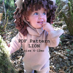 Può includere: Un bambino con un costume da leone beige con criniera e orecchie marroni. Il costume comprende un top con cappuccio e pantaloni abbinati. Il testo "PDF Pattern LION size 6-12mo" è stampato sul davanti. Il bambino è all'aperto.