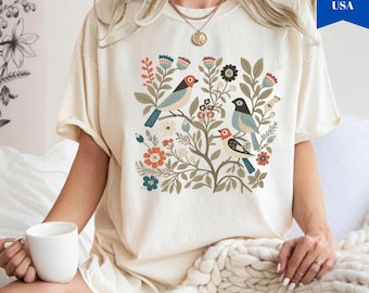 Camiseta de colores cómodos con diseño de pájaros y flores de arte popular - Camiseta estilo cottagecore con temática de jardín.