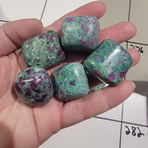 May include: Five tumbled green and pink ruby zoisite stones. The stones are smooth and have a speckled appearance.