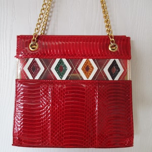Bolso vintage J Renee de piel de serpiente roja, años 80, con efecto piel de serpiente multicolor, detalles de vitral, asa de cadena dorada y paneles laterales blancos.