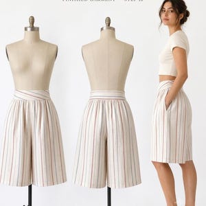 May include: Bloom Culotte Shorts Finished Garment Step 16. These culotte shorts feature a high-waisted design with a wide waistband and vertical stripes in muted red and blue on a cream background. The shorts have a loose, flowing fit.