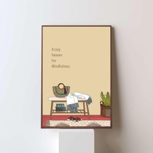 May include: A framed illustration depicts a cozy scene with a bench, a woven bag, a blanket, and a plant in a basket. The text "A cozy heaven For Mindfulness" is displayed on a beige background. The artwork has a minimalist style.