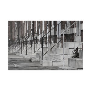 May include: A row of identical houses with black iron railings and white stone steps leading up to the front doors.
