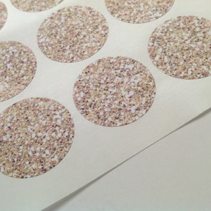 May include: Sheet of round stickers with a glittery, speckled design in shades of gold, brown, and white. The stickers are arranged in a grid pattern on a white backing.