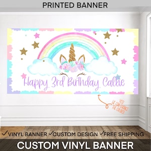 May include: A rectangular vinyl banner featuring a pastel rainbow, white clouds, and a gold glitter unicorn horn with floral accents. The text reads Happy 3rd Birthday Callie. The border consists of scalloped pastel shapes and gold stars.