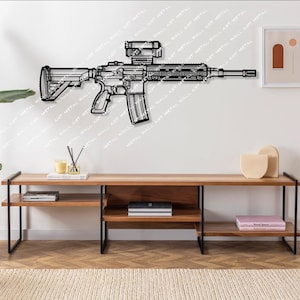 May include: A black metal wall art piece depicting a rifle with a scope. The artwork is mounted on a white wall above a wooden media console. The room is decorated with a plant, candles, and decorative objects.