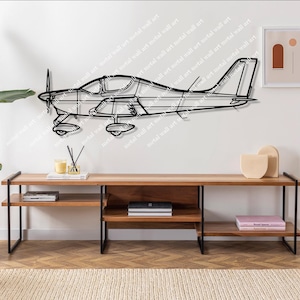 Op de afbeelding: Zwarte metalen vliegtuig wandkunst. Het vliegtuig is een gedetailleerde omtrek van een klein vliegtuig, gemonteerd op een witte muur boven een houten console. De kamer is ingericht met planten en minimalistische decoratie.