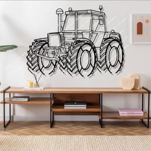 Puede incluir: Arte de pared de tractor de metal negro. La obra de arte representa un contorno detallado de un tractor, con neumáticos grandes y una cabina. El tractor está montado en una pared blanca sobre un mueble de TV de madera. La habitación tiene un diseño moderno y minimalista.