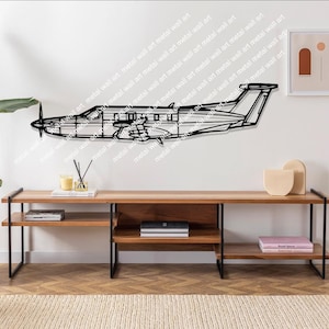 Könnte beinhalten: Eine schwarz-weiße Linienkunst-Silhouette eines kleinen Flugzeugs an einer weißen Wand. Das Flugzeug ist an der Wand über einem Holzregal mit schwarzen Metallbeinen montiert. Das Regal ist leer, bis auf ein paar Dekoartikel.