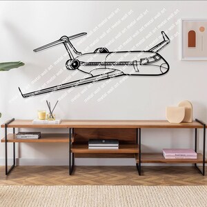 May include: A black metal airplane wall art sculpture mounted on a white wall. The airplane is in flight and has a detailed design. The wall art is displayed above a wooden shelf with books and decorative items.