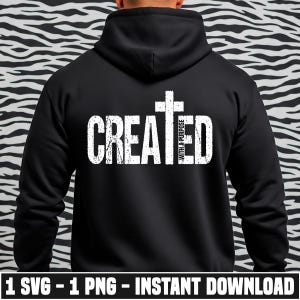 Puede incluir: Sudadera con capucha negra con la palabra "CREATED" en fuente blanca desgastada, una cruz blanca y las palabras "WITH A PURPOSE". La parte inferior de la imagen tiene el texto "1 SVG - 1 PNG - INSTANT DOWNLOAD".
