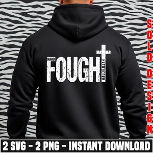 K&ouml;nnte beinhalten: Schwarzer Kapuzenpullover mit dem Text "HARD FOUGHT HALLELUJAH" in wei&szlig;er, abgenutzter Schrift und einer Kreuzgrafik. Der untere Teil des Bildes zeigt "2 SVG - 2 PNG - INSTANT DOWNLOAD". Der Kapuzenpullover ist einfarbig schwarz.