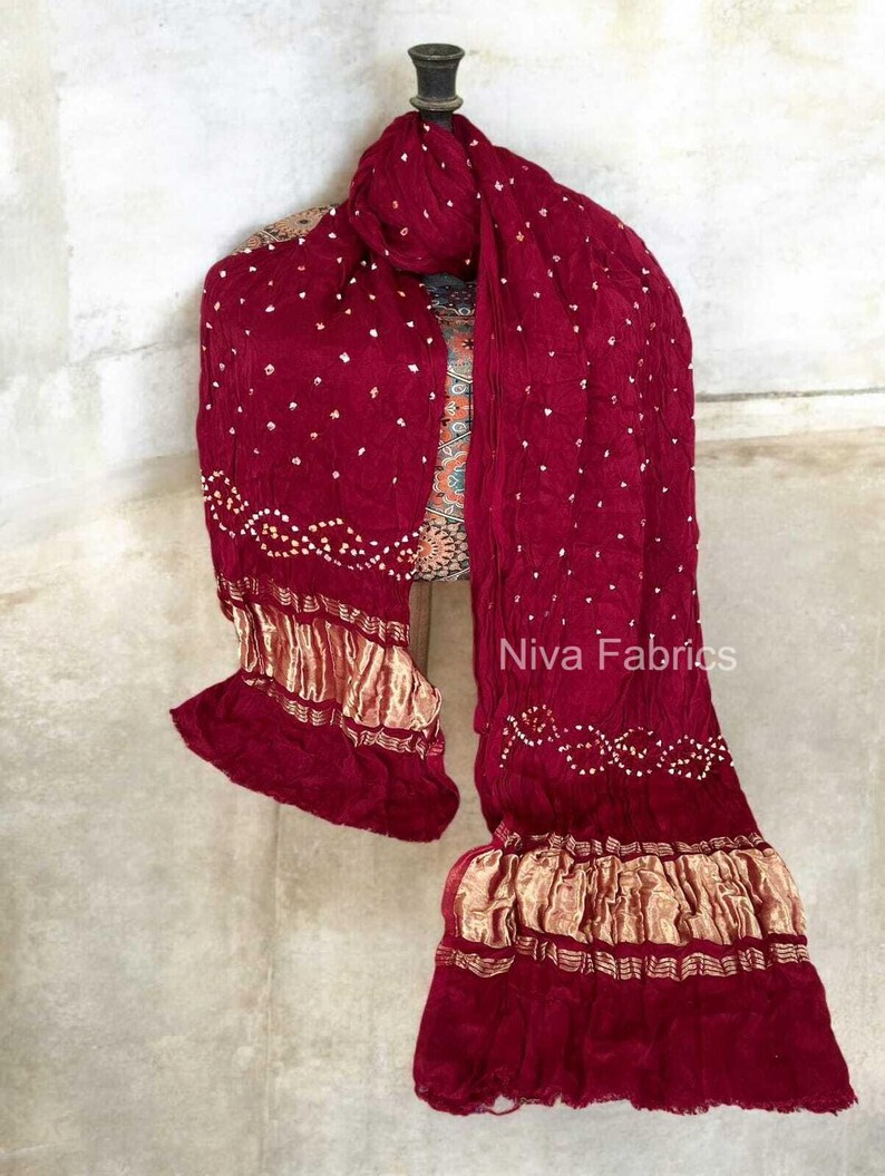 Op de afbeelding: Een witte keramische mok met een zwarte handgreep en de tekst "But First, Coffee" in een vetgedrukte, zwarte letter. De mok staat tegen een vage achtergrond, wat een gezellige setting suggereert.