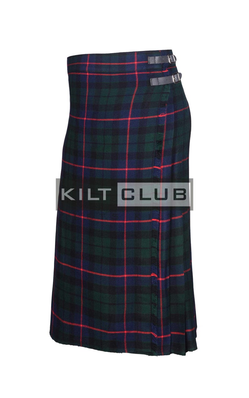 May include: A kilt in a tartan pattern of green, navy, and red. The kilt has two leather straps with buckles and the text "KILT CLUB".