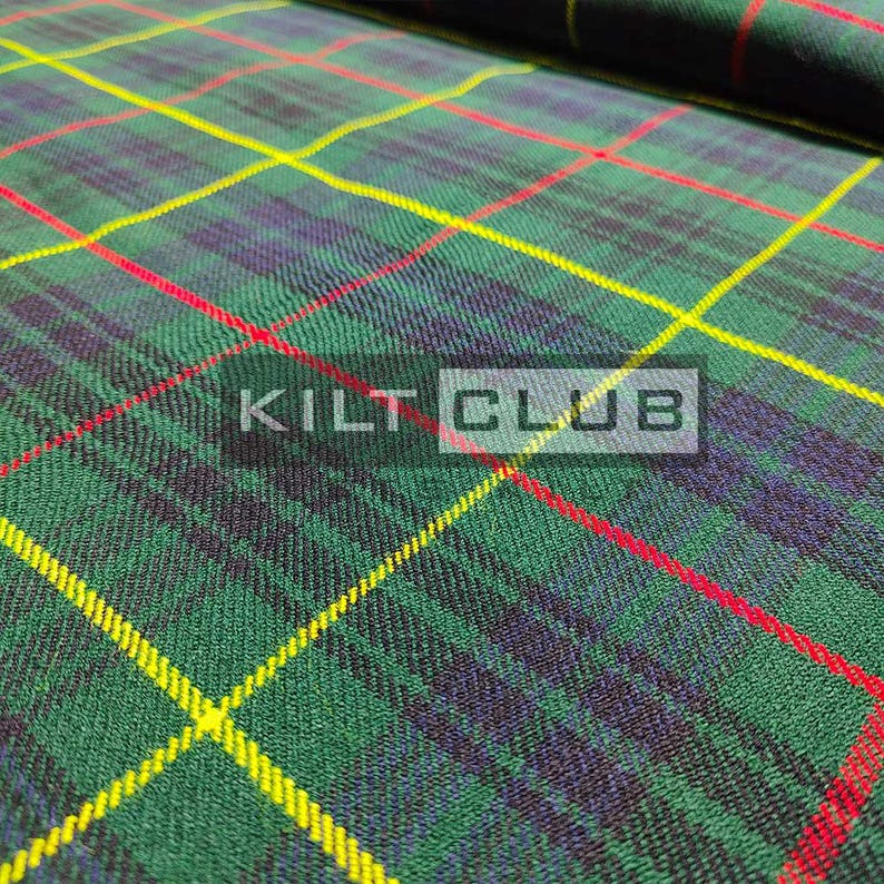 May include: Close-up of green, yellow, red, and navy blue plaid fabric. The fabric has a diagonal pattern with the text "KILT CLUB" in a white rectangle.