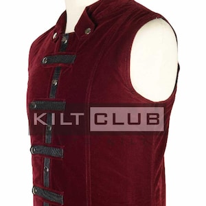 May include: A burgundy velvet vest with black accents and silver-tone buttons. The vest features a high collar and decorative black straps. The text "KILT CLUB" is visible on the front of the vest. This garment is likely part of a costume or historical clothing.