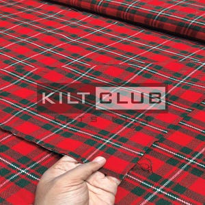 Puede incluir: Tela escocesa roja con líneas verdes y blancas que se cruzan. La tela tiene el texto "KILT CLUB" en un rectángulo blanco. Una mano sostiene la tela.
