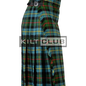 May include: A green, blue, and black plaid kilt with two leather straps and buckles. The kilt has a fringed edge and the text "KILT CLUB" is visible on the front.