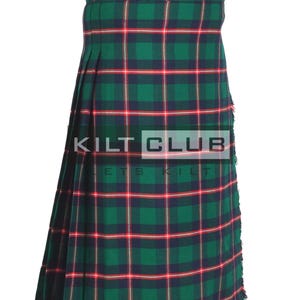 May include: A green, red, and navy plaid kilt with the text "KILT CLUB" in white. The kilt features a pleated design and is made of a woven fabric. The kilt is a traditional garment.