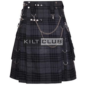 Puede incluir: Un kilt a cuadros grises y negros con detalles metálicos plateados, que incluyen cadenas, anillos y remaches. El kilt presenta un diseño plisado y el texto "KILT CLUB".