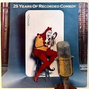 May include: A vintage vinyl record album cover featuring a jester in a red and yellow costume holding a microphone. The album title is "25 Years of Recorded Comedy" and the album artist is "Joker".