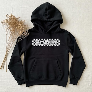 May include: Black hooded sweatshirt featuring a white checkered pattern and a line of Star Wars characters including Darth Vader, Chewbacca, R2-D2, and a Stormtrooper.