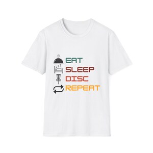 May include: White t-shirt with a graphic design that says "Eat Sleep Disc Repeat" with icons of a plate of food, a bed, a disc golf basket, and a repeat symbol.