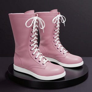 May include: A pair of pink, mid-calf boots with white laces and white soles. The boots are made of a smooth material and are displayed on a black, circular platform against a dark background. The boots have a classic lace-up design.