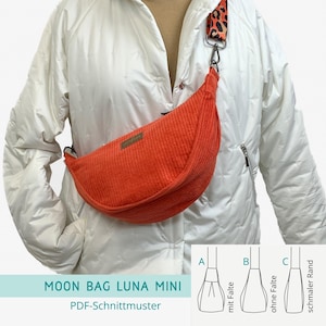 Könnte beinhalten: Eine orangefarbene Cord-Moon Bag Luna Mini Bauchtasche mit Leopardenmuster-Gurt. Die Tasche ist halbmondförmig und hat einen kleinen rechteckigen Aufnäher auf der Vorderseite. Die Tasche wird über einer weißen Jacke getragen. Der Text auf dem Bild lautet "MOON BAG LUNA MINI" und "PDF-Schnittmuster".