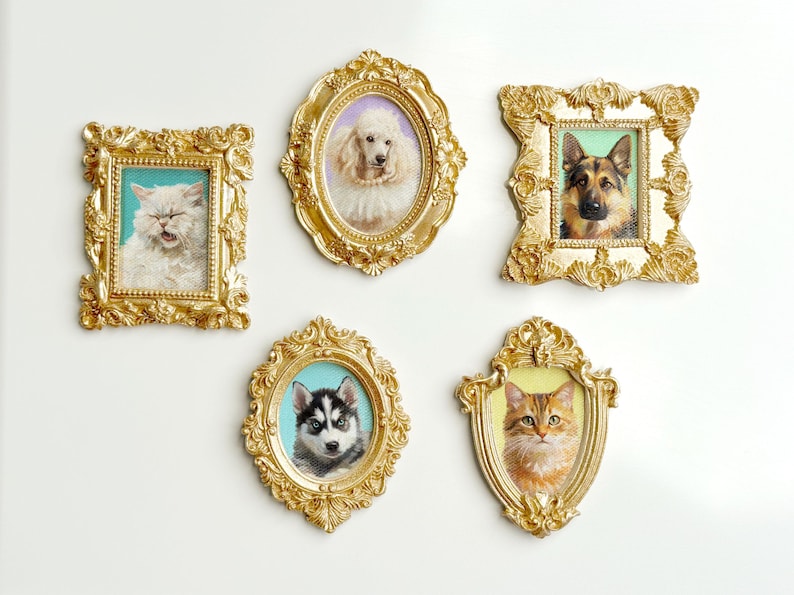 A set of five ornate miniature gold frames, each featuring a hand-painted pet portrait. The frames include a fluffy white cat with a teal background, a poodle with a pearl necklace on a lavender background, a German Shepherd with a green background, a Husky puppy with blue eyes on a teal background, and an orange cat with a yellow background. All frames are detailed with baroque-style carvings and displayed against a light background.