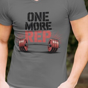 May include: Gray V-neck t-shirt with the text "ONE MORE REP" and a barbell graphic. The barbell has red weights and is centered on the shirt. The words "Summer Vibes" are in the upper right corner.