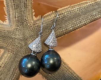 Pendientes colgantes de aro con perlas negras tahitianas y conchas marinas.