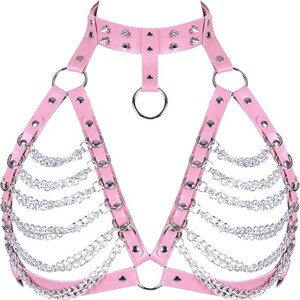 May include: Pink faux leather harness with silver-tone chain and ring accents. The harness features a choker-style collar with studded details and a halter design. The chains drape across the chest, creating a unique and edgy look.