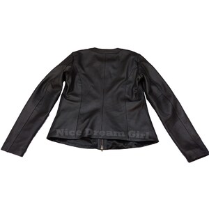 May include: A black leather jacket with a round collar and long sleeves. The jacket has a zipper closure and the text "Nice Dream Girl" is printed at the bottom. The jacket is displayed against a white background.