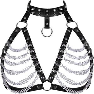 May include: Black faux leather body harness with silver-colored chain and ring accents. The harness features a choker-style neckline with studded details and adjustable straps. The design includes multiple chains that drape across the chest.