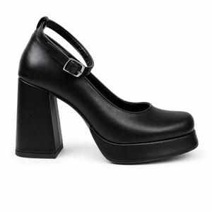 May include: A black platform shoe with a square toe and a high, thick block heel. The shoe features a thin ankle strap with a silver-toned metal buckle closure. The design includes a smooth finish and a substantial platform sole under the forefoot.