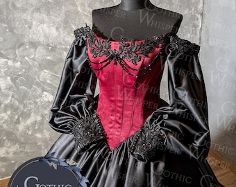 Op de afbeelding: Een zwart en rode gothic jurk op een mannequin. De off-the-shoulder jurk heeft een rood lijfje met zwarte kant en kralenaccenten. De lange mouwen zijn van zwarte satijn, en de rok is wijd en zwierig.