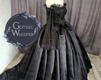 May include: A black gothic-style gown with a sweetheart neckline and off-the-shoulder sleeves. The bodice features intricate lace detailing, and the full skirt flows into a train. The dress is displayed on a mannequin. The logo "Gothic Whisper" is visible.