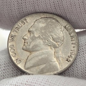 Op de afbeelding: Een zilveren Amerikaanse halve dollar munt met het profiel van Thomas Jefferson op de voorzijde. De munt heeft de tekst "LIBERTY 1942" en "IN GOD WE TRUST".