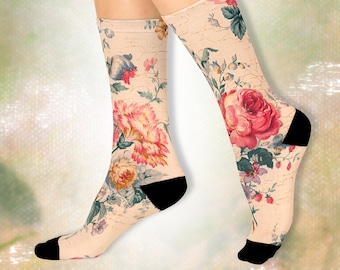 May include: A pair of cream-colored socks with a floral print featuring pink, red, and yellow flowers. The socks have black heels and toes.