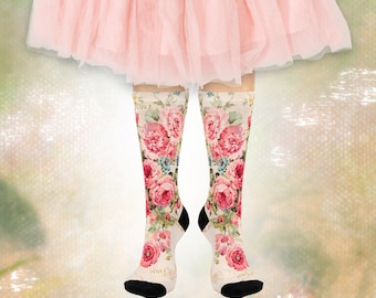 May include: A pair of knee-high socks with a floral pattern featuring large pink roses, blue accents, and green leaves on a cream background. The socks have black heels and toes, with the word "LOVE" printed on the top and toe.