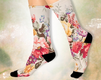 May include: A pair of white socks with a floral print. The socks have a black heel and toe.