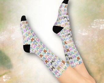 May include: A pair of crew-length socks featuring an all-over print of colorful butterflies in various shades of blue, purple, orange, and pink. The socks have solid black cuffs at the top and solid black toe and heel sections for contrast.