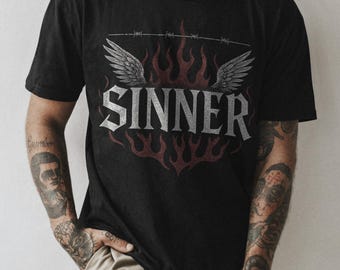 May include: Black t-shirt with a graphic of a red and white flame with wings and the word "SINNER" in white lettering. The text "I LOVE I HATE" is visible on the shirt.
