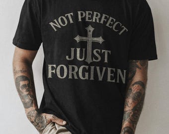 May include: A black t-shirt with a white graphic design that says "Not Perfect Just Forgiven" with a cross in the center.