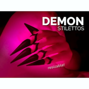 May include: A set of black, pointed, claw-like finger extensions with a sharp, elongated design. The text DEMON STILETTOS and resizable! is displayed in white against a vibrant, glowing pink background that illuminates the dark accessories.